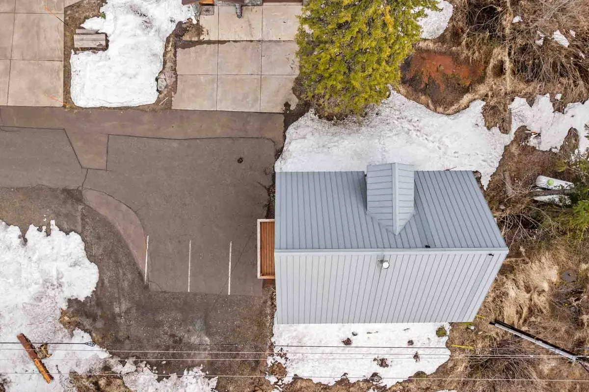 A modern chalet sits amidst a snow-covered landscape, surrounded by tall trees with soft evening light filtering through. The building’s contemporary design is complemented by the natural winter setting, creating a welcoming outdoor environment for groups to gather and explore.